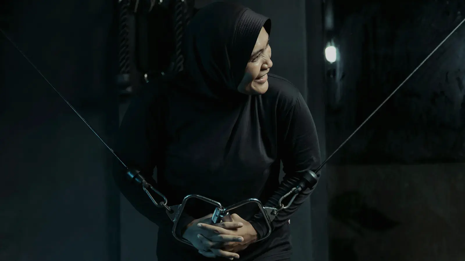 Woman training on the cable machine, focused